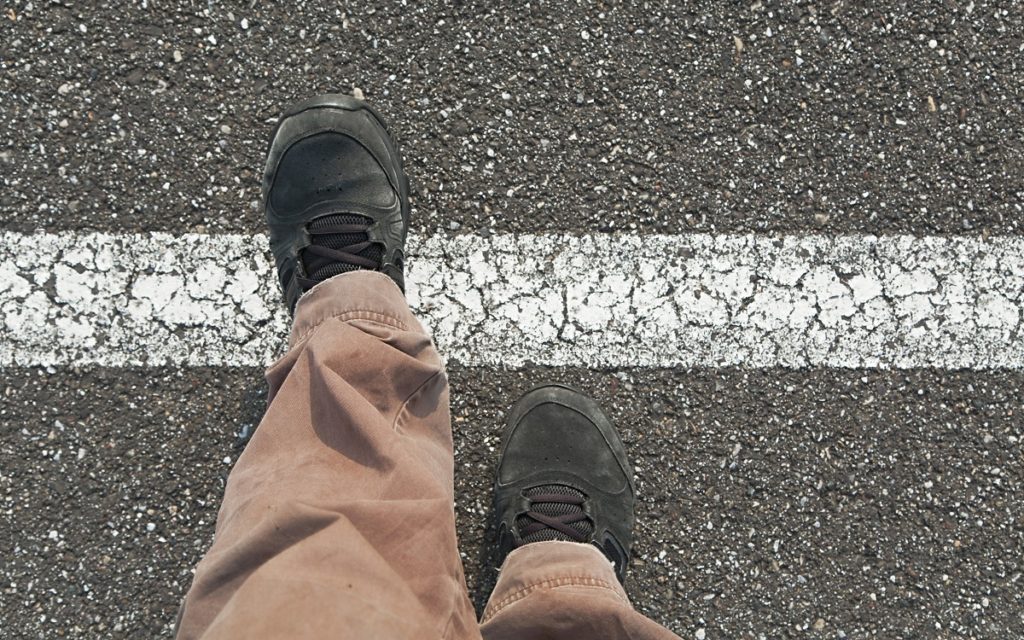 Feet moving over a white line on the ground