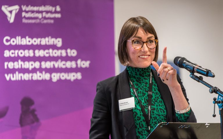 Dr Kate Brown stood at a lectern speaking at an event