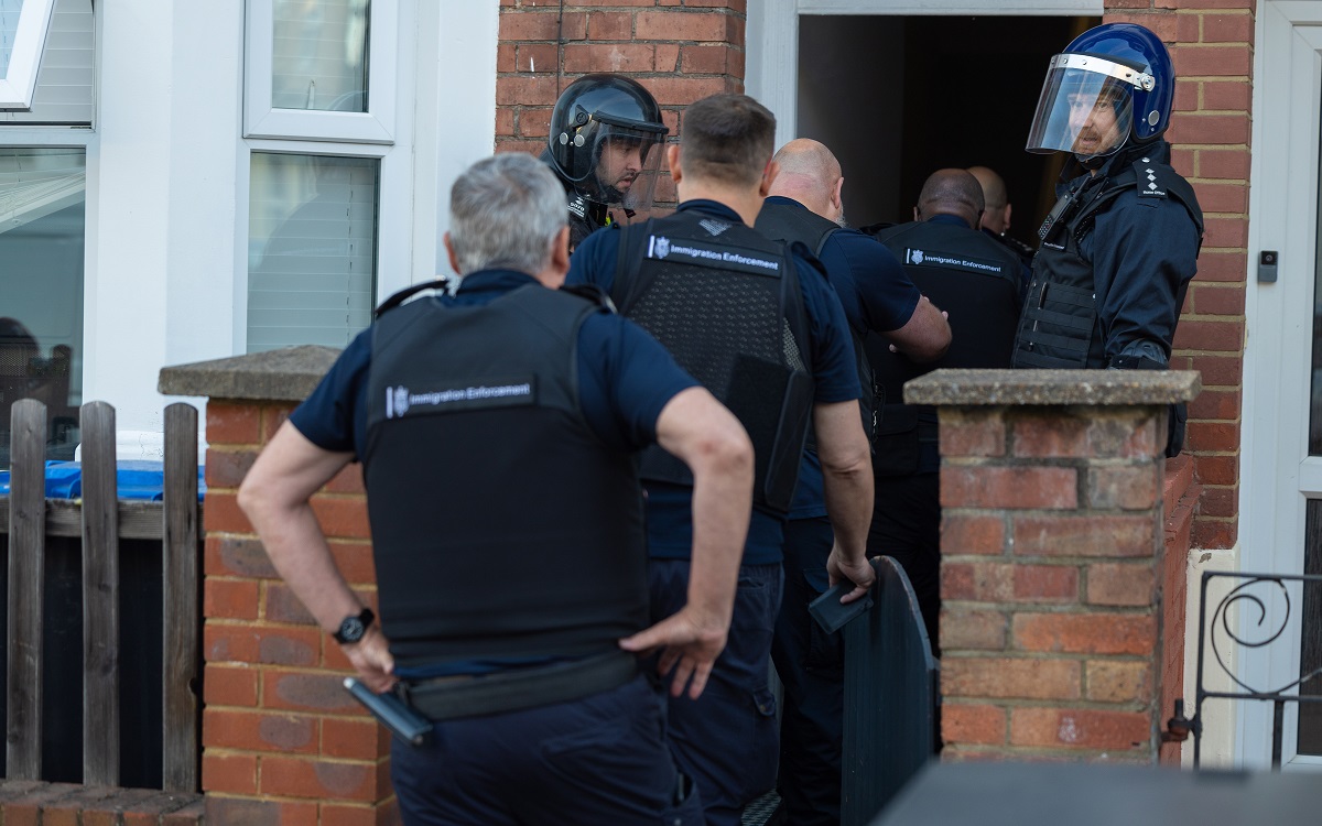 Immigration Enforcement officers entering a house