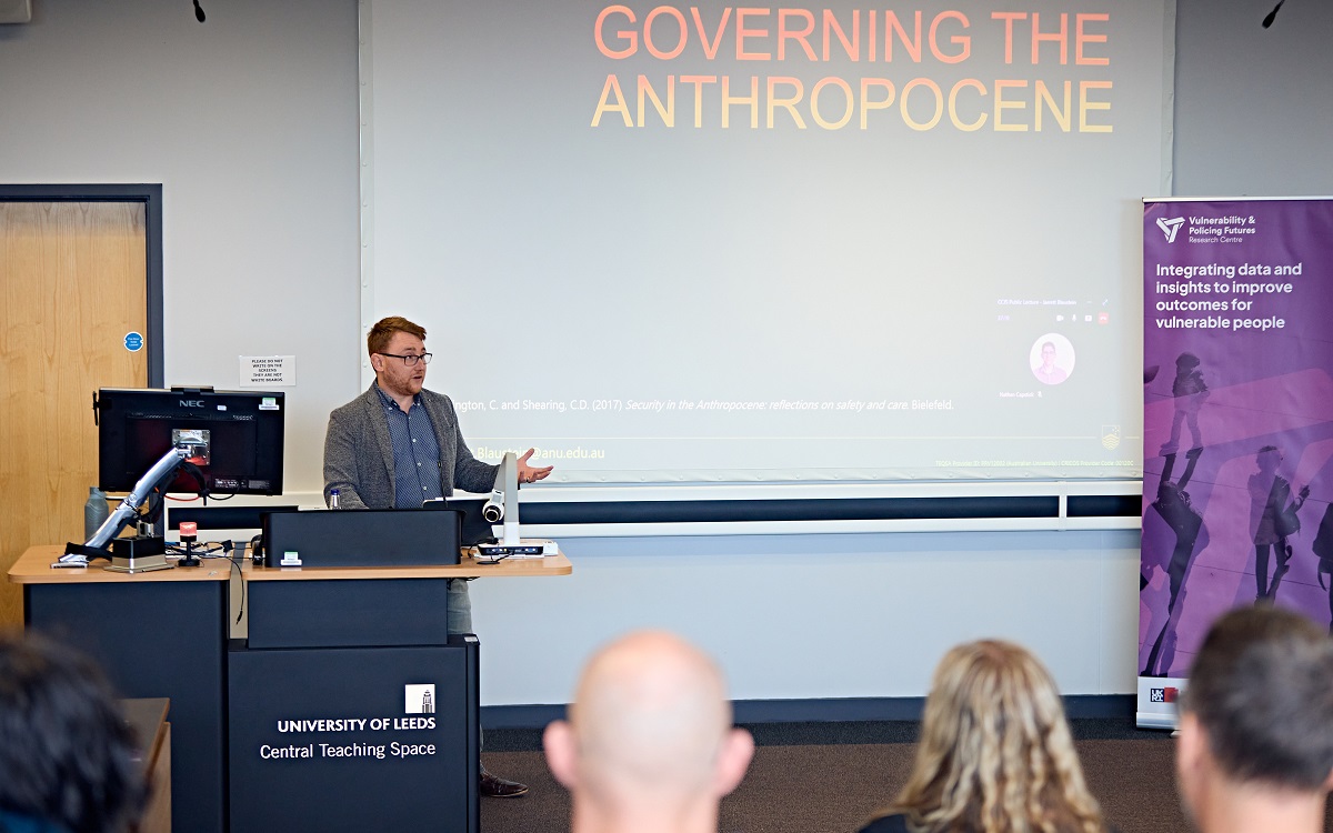Dr Jarrett Blaustein stood at a lectern delivering a public lecture to an audience