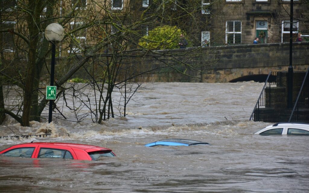 Three cars under water as river floods. Photo by Chris Gallagher on Unsplash.