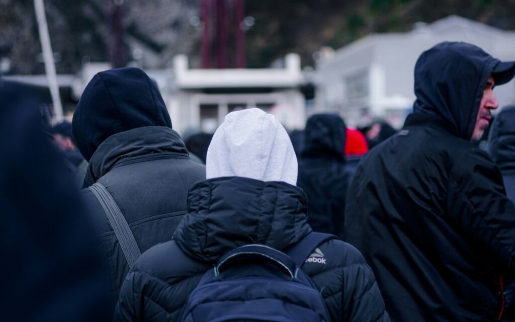 Backs of a group of people wearing coats and hoodies
