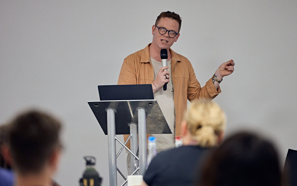 Darren McGarvey stood at a lectern delivering a keynote address