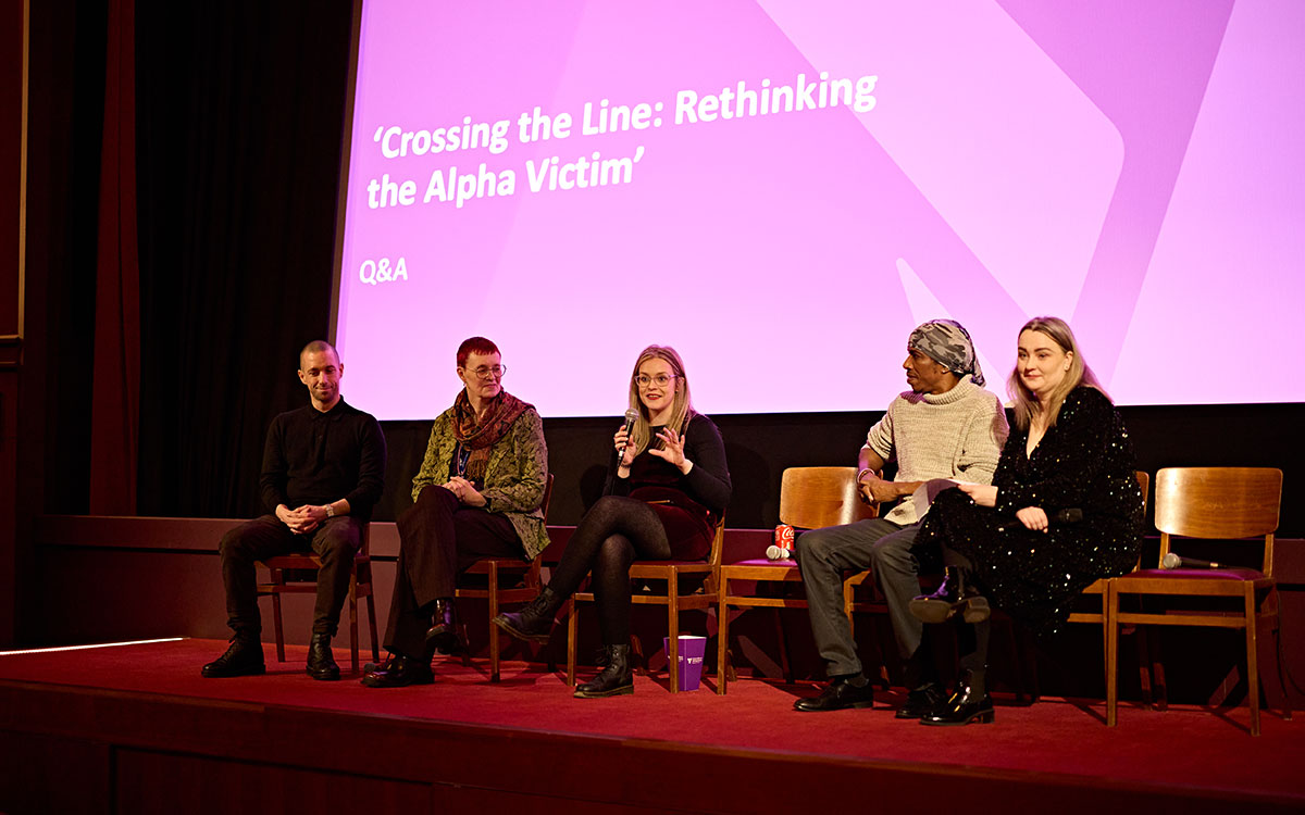 Panel members sat on chairs on stage in discussion at the Crossing the Line film premiere
