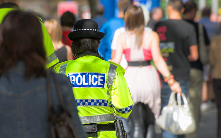 UK police officer patrolling a busy street