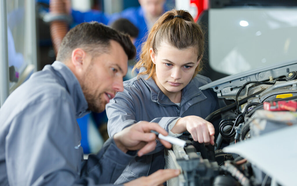 Mechanic with young, female apprentice